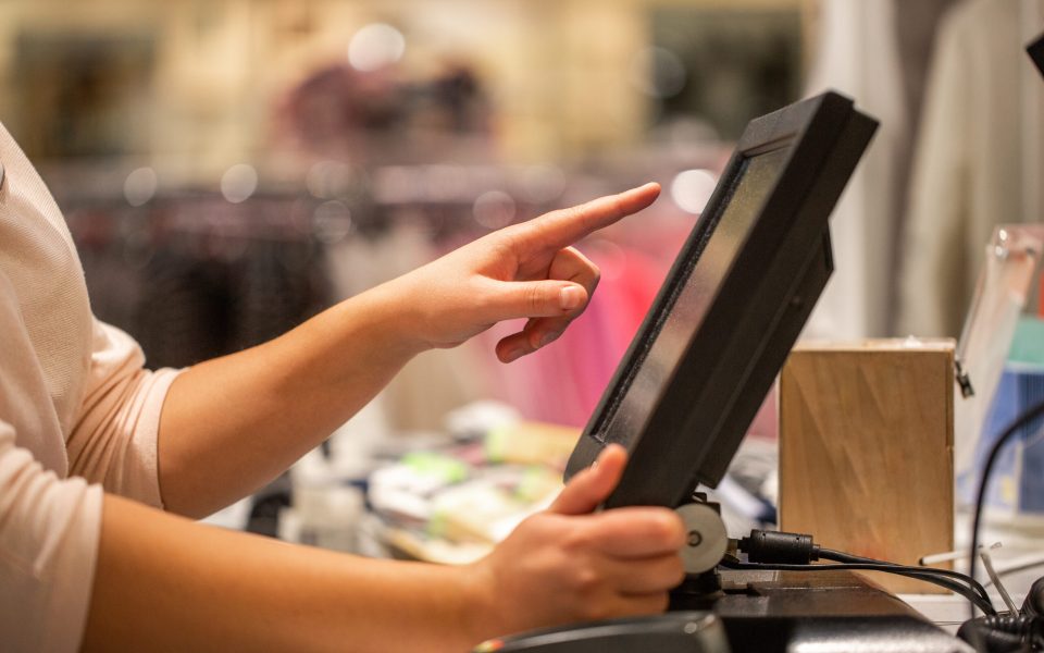 Young woman hands scaning / entering discount / sale on a receip Young woman hands scaning / entering discount / sale on a receipt, touchscreen cash register, market / shop, finance concept, business